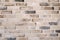 Brick wall of old faded beige bricks as a background. Grunge loft texture.