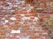 Brick wall. Old flaky white paint peeling off a grungy cracked wall. Cracks, scrapes, peeling old paint and plaster on background