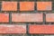 Brick wall with red bricks Red, orange brick background, arranged in complex horizontal rows in layers interlocked with cement.