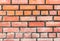 Brick wall with red bricks Red, orange brick background, arranged in complex horizontal rows in layers interlocked with cement.