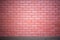 The brick wall of red color with a cement base on the bottom. Ideal for use as a design background or for adding text.