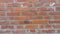 Brick wall of red-orange bricks and blocks. Lightly worn surface. Neat masonry, cement between the rows. Grunge background.