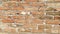 Brick wall of red-orange bricks and blocks. Lightly worn surface. Neat masonry, cement between the rows. Grunge background.