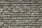 Brick wall texture, background in grey, faded color. Masonry-style concrete wall. Stylish fencing, made of decorative stone