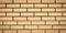 Brick wall texture, stone background. Yellow bricks pattern. Wide panorama, panoramic banner. Architecture facade, tiled surface,