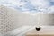 Brick wall and wooden floor with blue sky and clouds.