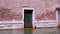 Bricked up and green doors of ancient building near channel