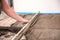 Bricklayer aligns cement screed in a newly built house