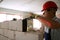 Bricklayer applies adhesive glue on autoclaved aerated concrete blocks with notched trowel. Brickwork worker contractor