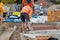 Bricklayer cutting concrete blocks using petrol disc cutter while working on residential housing development construction site