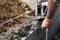 Bricklayer in glove spreading concrete to build a wall on construction site