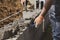 Bricklayer in glove spreading concrete to build a wall on construction site