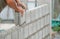 Bricklayer hands installing brick block on construction site
