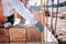 Bricklayer industrial worker installing brick masonry on exterior wall with trowel putty knife and level