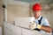 Bricklayer or mason lays bricks to construct wall of autoclaved aerated concrete blocks. Brickwork worker contractor