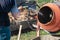 Bricklayer preparing concrete with a cement mixer to build a wall at a construction site