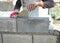 Bricklayer putting down another row of bricks in site