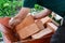 Bricklayer is taking red bricks from a metal wheelbaroow to construct masonry on a construction site