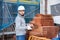 Bricklayer taking red bricks from stack