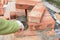 Bricklayer Worker Installing Red Blocks and Caulking Brick Masonry Joints Exterior Wall with Trowel putty Knife. Bricklaying Mason