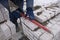 A bricklayer works on a construction site, laying concrete blocks, leveling a brick wall with a level.