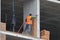 A bricklayer works at a construction site. Work is underway to lay a red brick wall. A new house is being built.