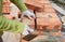 Bricklayers hands in masonry gloves bricklaying on House Construction Site. Bricklaying, Brickwork.