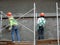 Brickwall plastered by construction workers using cement plaster.