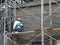 Brickwall plastered by construction workers using cement plaster.