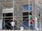 Brickwall plastered by construction workers using cement plaster.