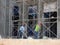 Brickwall plastered by construction workers using cement plaster.