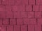 Brickwork of big bright textured crimson pink bricks, geometric square stones. Floor in a street, tiles underfoot.