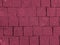 Brickwork of big bright textured crimson pink bricks, geometric square stones. Floor in a street, tiles underfoot