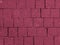 Brickwork of big bright textured crimson pink bricks, geometric square stones. Floor in a street, tiles underfoot