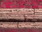 Brickwork of big grey bricks between bright pink crimson geometric horizontal bricks bonded with grout. Background