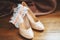 Bridal beige wedding shoes with garter, wooden background. Marriage concept