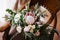 Bridal bouquet of white and pink roses, protea, eucalypt tree branches, veronica and peonies on the wooden chair