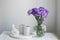 Bridal bouquets of lilac carnations in four round glass vases different sizes as table decoration