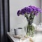 Bridal bouquets of lilac carnations in four round glass vases different sizes as table decoration