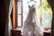 Bridal elegance Wedding dress hangs on a curtain rail near window