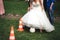 Bridal games. Bride making slalom with football ball among traffic cones. Wedding day concept.