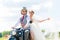 Bridal pair driving motor scooter wearing gown and suit