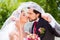 Bridal pair kissing under veil at wedding