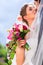 Bridal pair kissing under veil at wedding