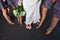 A bridal party ladies stand on a road and display their shoes