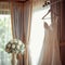 Bridal room ambiance Wedding dress hung elegantly on a curtain rail