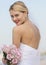 Bride In Backless Wedding Dress Holding Flower Bouquet Against S