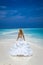 Bride on the beach. Stylish female model in elegant long gown dress on the Maldives beach. Elegance. Bride on Maldives. Bridal