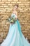 Bride in a beautiful turquoise dress in anticipation of wedding. Blonde in lace dress sea green with a bouquet . Happy bride