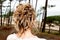Bride behind head blonde wedding hairstyle with decoration in rear view outdoors